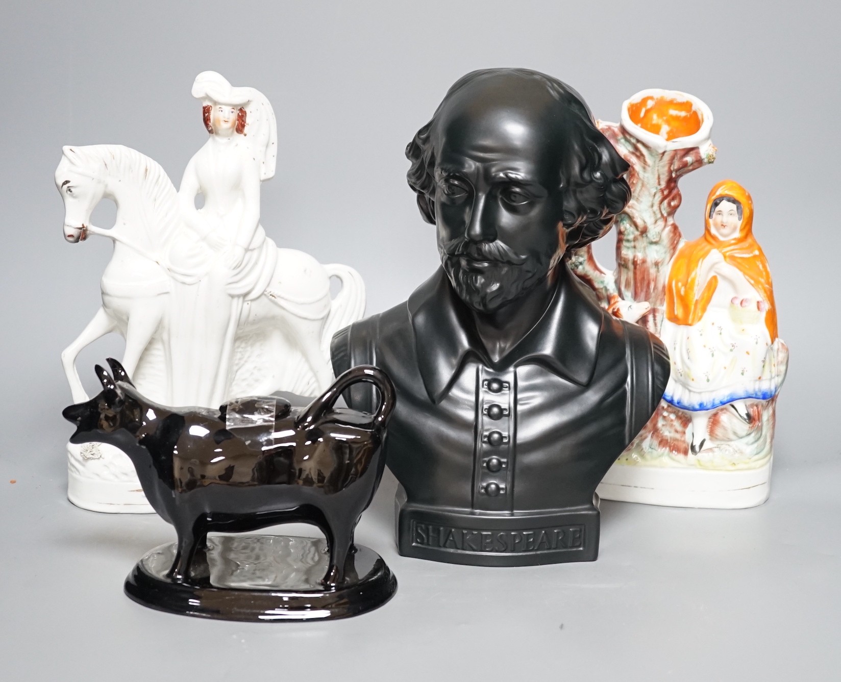 A Wedgwood glazed black basalt bust of Shakespeare, two Victorian Staffordshire figures and a cow creamer, tallest 27cm